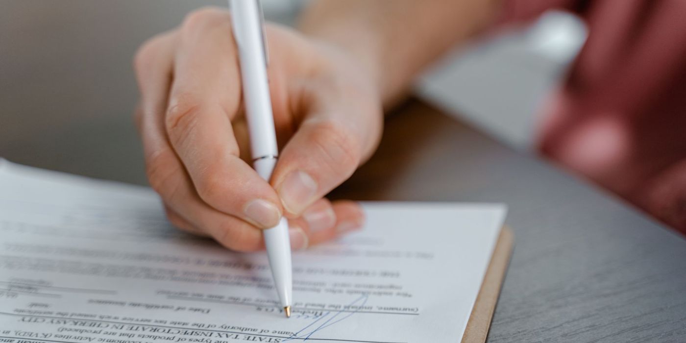 Tangan menandatangani dokumen dengan pen