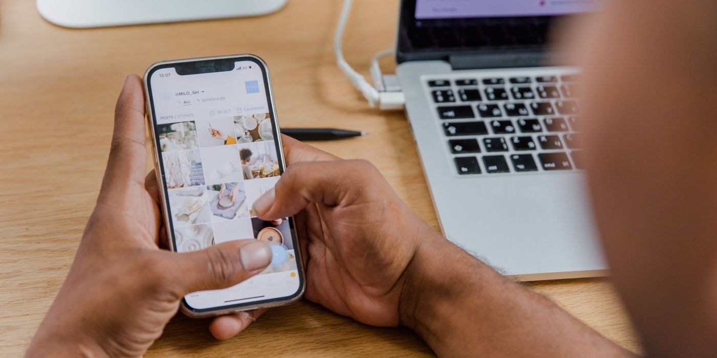Tangan memegang telefon pintar untuk semakan dalam talian