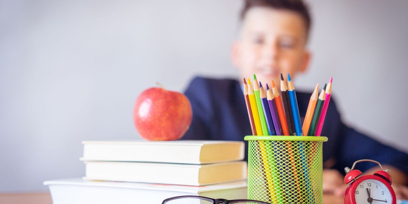 Beg sekolah, buku dan alat tulis di atas meja